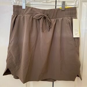 Tan activewear skort with a tie waist and pockets, size small